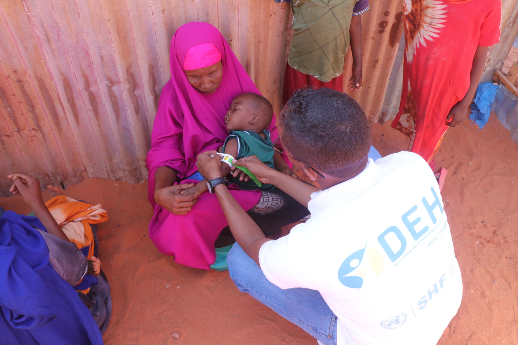 DEH staff conducting mass screening in Galkayo, using MUAC tapes to assess the nutritional status of children 6-59 months and pregnant and lactating women.